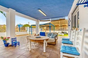 a patio with a table and chairs and a couch at Villa Mediterraneo in Oliva