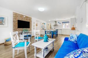 a living room with a blue couch and a kitchen at Villa Mediterraneo in Oliva