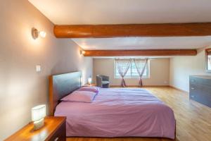 a bedroom with a large bed with pink sheets at Villa du soleil levant in Apt