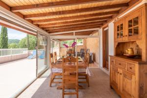 a dining room with a wooden table and a balcony at Villa du soleil levant in Apt