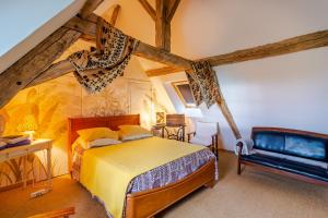 a bedroom with a yellow bed in a attic at Chambres d'hôtes Exotique in Saint-Jory-las-Bloux
