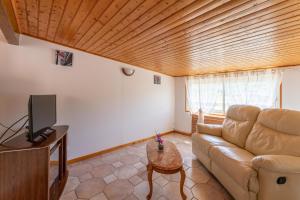 a living room with a couch and a tv at Villa du soleil levant in Apt