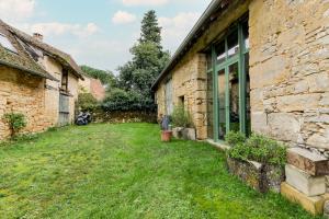an empty yard next to a stone building at Chambres d'hôtes Exotique in Saint-Jory-las-Bloux