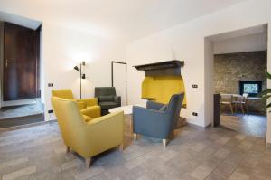 a living room with yellow and blue chairs and a fireplace at Workation Castle in Carlazzo