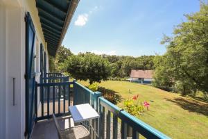 a balcony with a table and chairs and a yard at Txori Etxea in Arcangues