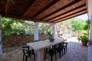 a wooden table and chairs on a patio at Casa delle Mimose in Orosei