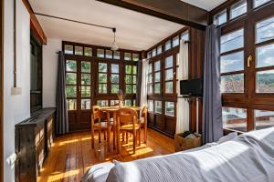 a bedroom with a table and chairs and windows at Casa Florenta G2 in Cangas de Onís +20 photos