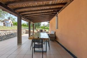 an outdoor patio with a wooden table and chairs at Agriturismo Per Caso in Carignano