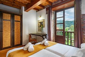 a bedroom with two beds and a desk and a window at Casa Florenta G2 in Cangas de Onís