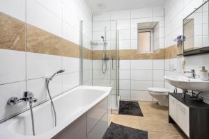 a bathroom with a tub and a sink and a toilet at Gera Apartment in Gera +18 photos