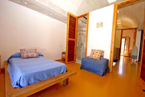 a bedroom with a bed and a chair in it at Sa Portassa in Felanitx