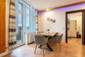 a dining room with a table and chairs and a large window at Gera Apartment in Gera