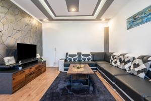 a living room with a couch and a tv at Gera Apartment in Gera
