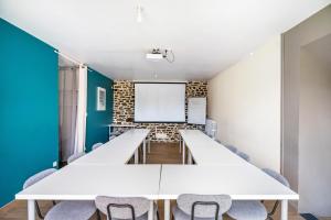 a conference room with white tables and chairs and a whiteboard at Gîte Les Hervelines in Pleudihen-sur-Rance +31 photos