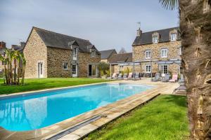 a large swimming pool in front of a house at Gîte Les Hervelines in Pleudihen-sur-Rance