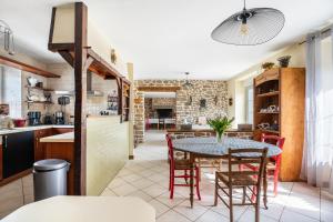 a kitchen and dining room with a table and chairs at Gîte Les Hervelines in Pleudihen-sur-Rance