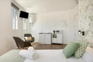 a white room with a bed and a kitchen at Casa Milano 3 in Jerez de la Frontera