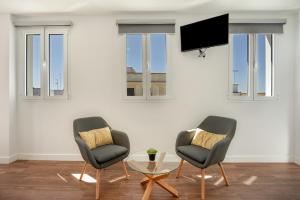 two chairs and a table in a room with windows at Casa Milano 3 in Jerez de la Frontera