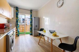 a kitchen with a table and chairs and a refrigerator at Barbecue and Beach – 200m away in Armação de Pêra