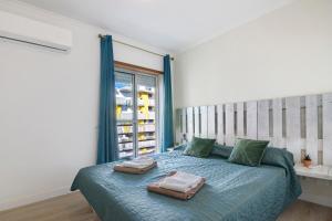 a bedroom with a bed with two bags on it at Barbecue and Beach – 200m away in Armação de Pêra