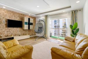 a living room with a couch and a tv at Barbecue and Beach – 200m away in Armação de Pêra