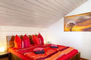 a bedroom with a large bed with red pillows at Haus Erichsen in Perlesreut +39 photos
