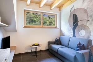 a living room with a blue couch and a window at Wiesgut Ferienwohnung Golden in Tesimo
