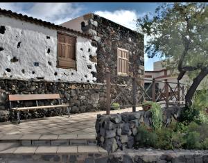 a stone building with a bench in front of it at Studio Tagoro in Guía de Isora