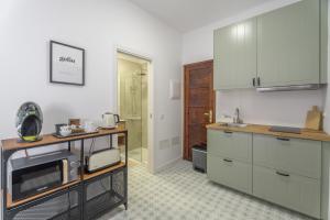 a kitchen with white cabinets and a microwave at Studio Tagoro in Guía de Isora