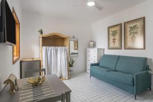 a living room with a blue couch and a table at Studio Tagoro in Guía de Isora