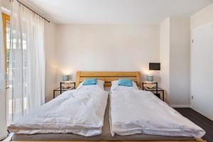 two beds in a small bedroom with a window at Haus Regina in Löffingen