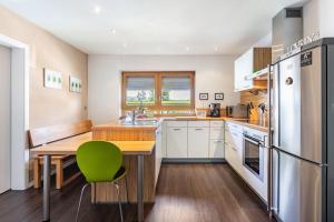 a kitchen with a table and a green chair at Haus Regina in Löffingen