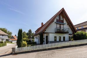 a house with a wooden roof and a fence at Haus Regina in Löffingen