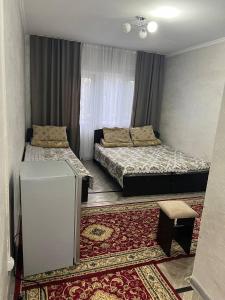 a bedroom with two beds and a rug at Эдем ИссыкКуль in Bosteri