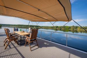 a table and chairs on the deck of a boat at Naturerlebnis Hausboot Frigga Woma in Fürstenberg