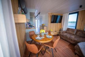a living room with a table and chairs and a couch at Naturerlebnis Hausboot Frigga Woma in Fürstenberg