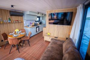 a living room with a couch and a table and a kitchen at Naturerlebnis Hausboot Frigga Woma in Fürstenberg
