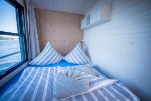 a bed in a small room with a window at Naturerlebnis Hausboot Frigga Woma in Fürstenberg