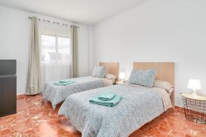a bedroom with two beds and a window at Casa Axarquia 2 in Vélez-Málaga