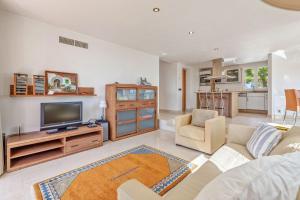a living room with a couch and a tv at Mon Obert Cala Serena in Felanitx