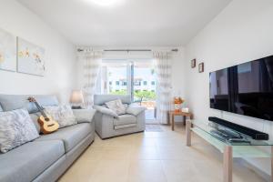 a living room with a couch and a flat screen tv at Cala Egos Villa - S'Estel in Cala d´Or