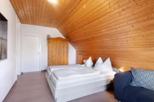 a bedroom with a bed and a wooden ceiling at Gästehaus Perlmuschel in Iznang