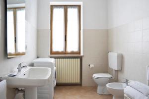 a white bathroom with a sink and a toilet at Casa Pianezzo Dogliani in Dogliani +22 photos