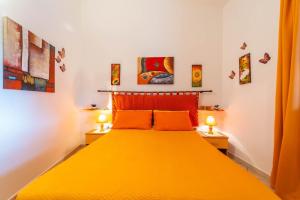 a bedroom with a yellow bed with two lamps at Trilocale Luana in Nuditta