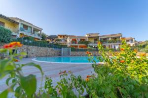 a swimming pool in a yard with some flowers at Trilocale Luana in Nuditta