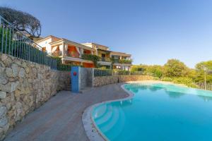 a large swimming pool next to a stone wall at Trilocale Luana in Nuditta +20 photos