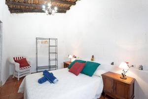 a bedroom with a white bed and a chair at Casa El Drago in Arico +18 photos