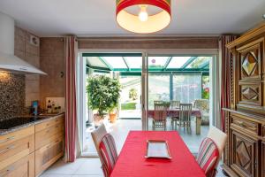 a kitchen with a red table and chairs at Gure Xokoa in Urrugne