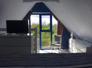 a bedroom with a bed and a desk and a window at Gîte De Ty Louti in Plouyé