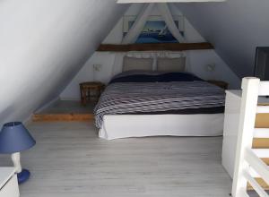 a bedroom with a bed in a attic at Gîte De Ty Louti in Plouyé